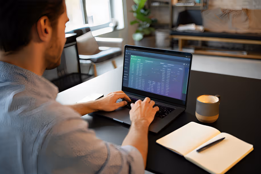Fractional executive working on a laptop displaying a CRM sales pipeline interface, with an open notebook and coffee cup on the desk.